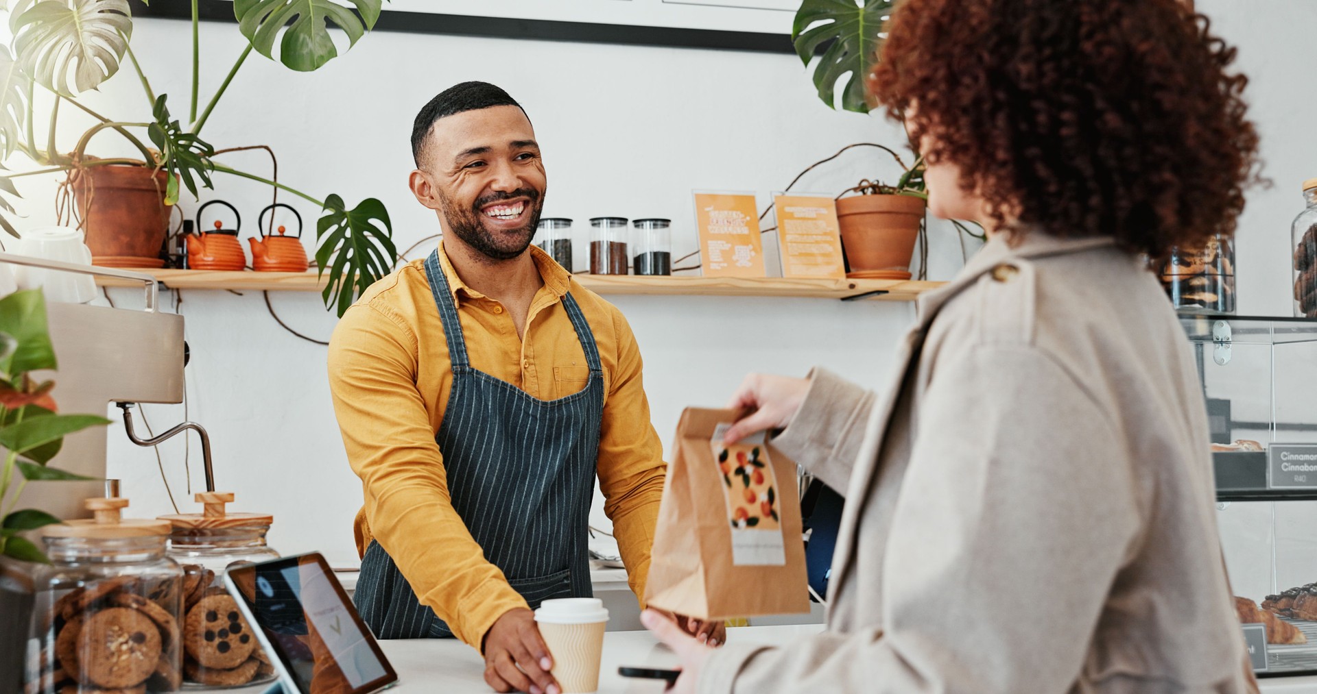 Waiter, bag and customer in cafe for hospitality, lunch and online payment with coffee and package. Woman, server and smile in restaurant for sale, exchange and breakfast with professional service